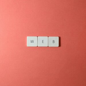 A minimalist photo featuring the word 'WEB' spelled with keyboard keys on a red background.